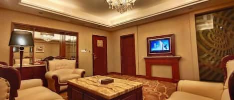A hotel room with a chandelier, a television, a fireplace, and a large window.
