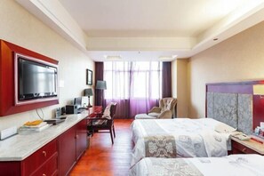 A hotel room with a TV, desk, chair, two beds, and a window with curtains. - Xingkai Garden Hotel (Panzhou)