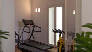 A home gym with a treadmill, stationary bike, and weights. - WeLive Trapani - Deluxe First Floor Apartment (Trapani)
