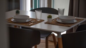 A dining table set with white bowls, clear glasses, and a small potted plant. - WeLive Trapani - Superior Second Floor Apartment (Trapani)
