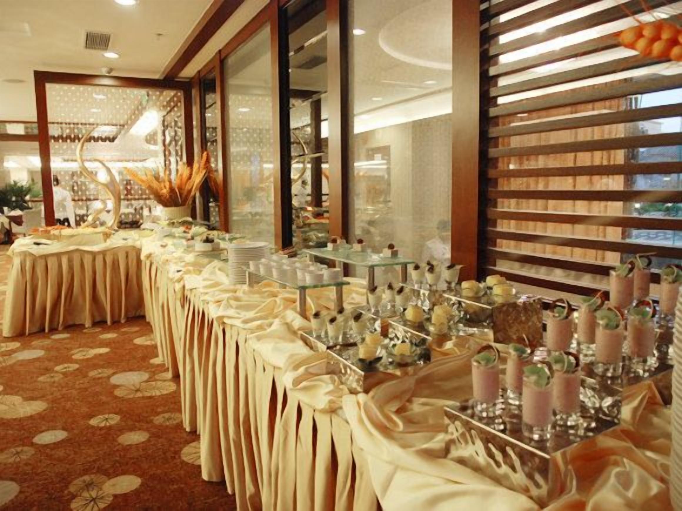 A banquet hall with long tables, floral centerpieces, and a patterned carpet.
