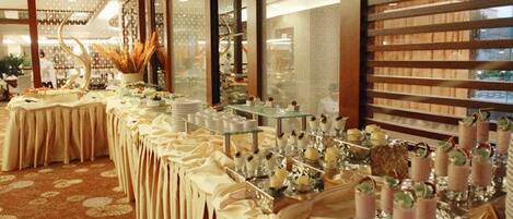 A banquet hall with long tables, floral centerpieces, and a patterned carpet.