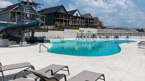 Ein Swimmingpool mit Liegestühlen und einer Wasserrutsche.