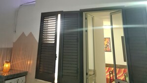 Una habitación con techo de listones, una puerta que da a otra habitación y un calentador fijado a la pared.