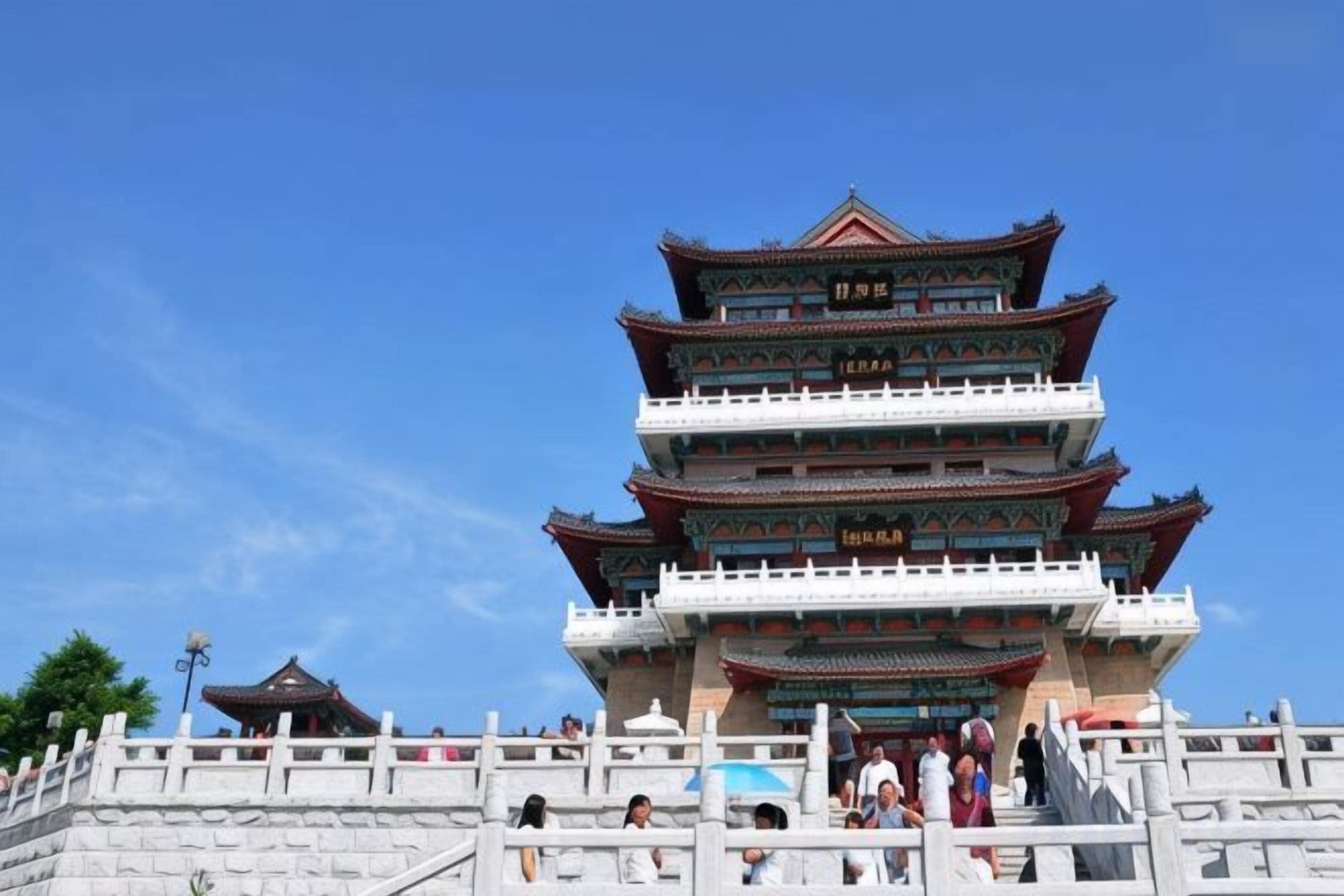 A multi-tiered traditional building with a white railing in front.