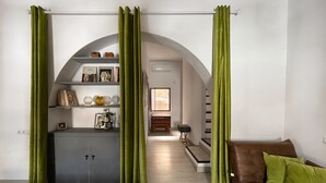 A living room with a sofa, a coffee table, and a bookshelf. There is a staircase leading to another level. - Village house with patio (Altea)