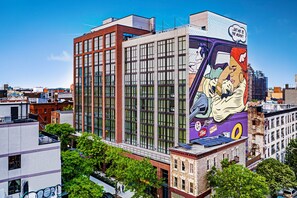 A modern building with large windows and a mural on the side. - Moxy Brooklyn Williamsburg (Brooklyn)