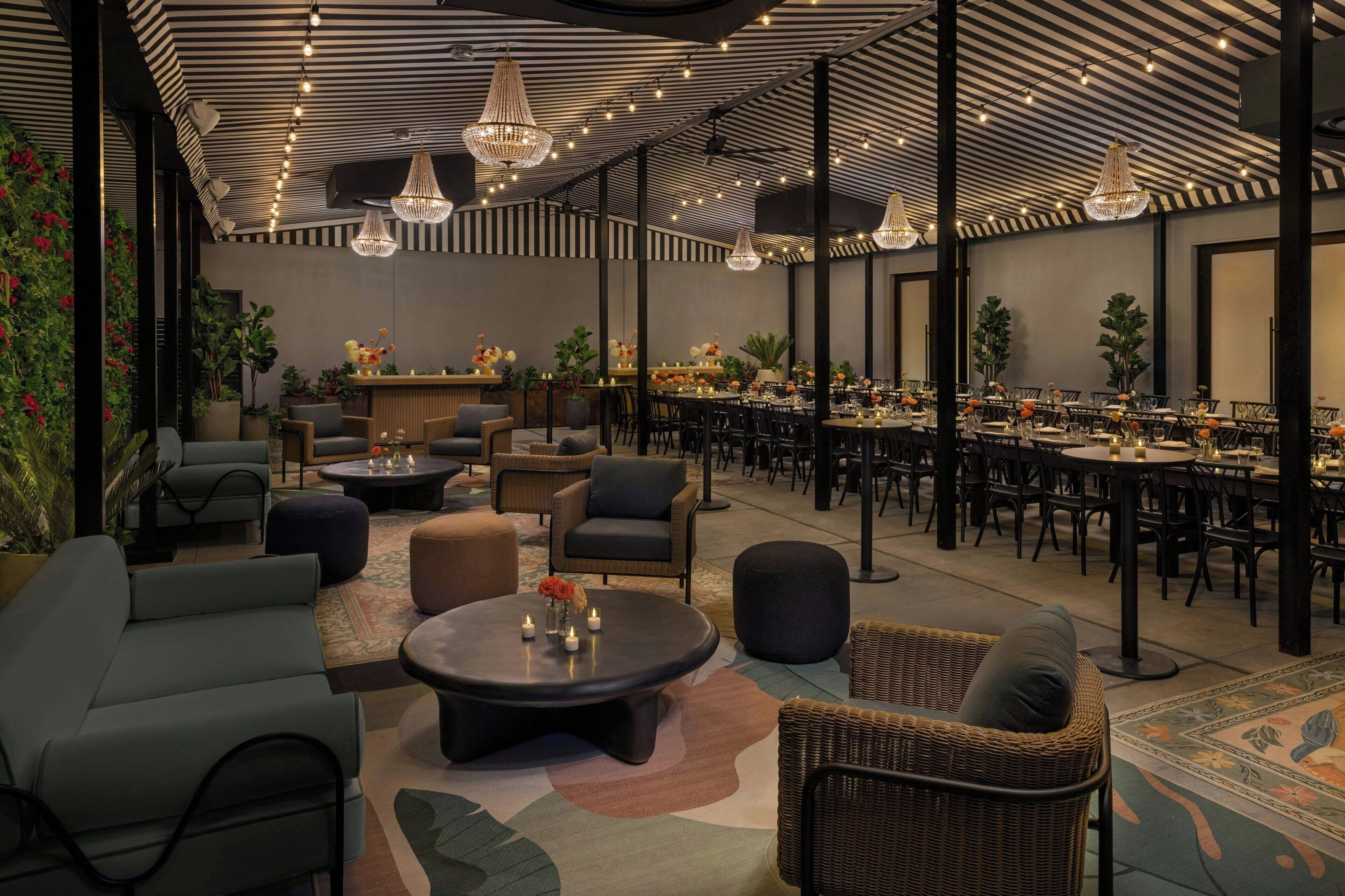 A spacious indoor area with multiple dining tables and chairs, surrounded by comfortable seating areas with sofas and ottomans.