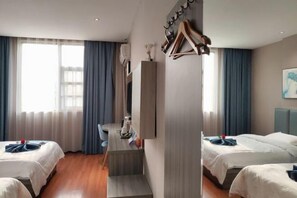 A hotel room with two beds, a desk, and a chair. There is a staircase leading to an upper level. - SET CHAIN HOTOL (Huanggang)