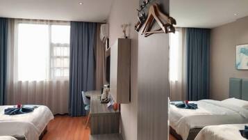 A hotel room with two beds, a desk, and a chair. There is a staircase leading to an upper level.