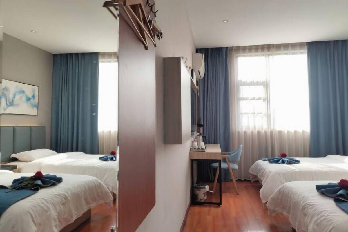 Una habitación de hotel con dos camas, un escritorio y una silla.