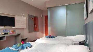 A hotel room with two beds, a flat-screen TV, a minibar, and a sliding door closet.