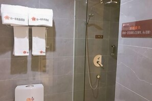 A shower area with a glass door, a towel dispenser, and a sign with instructions. - SET CHAIN HOTOL (Huanggang)
