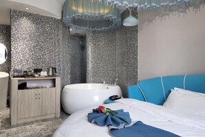 Un baño moderno con una bañera grande, un mueble de madera y un cabecero tapizado en azul.