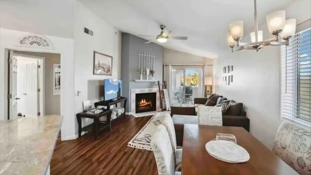 A spacious living room with a fireplace, a dining area, and a kitchen visible in the background. - Cozy Cowboy Condo (Paradise Valley)