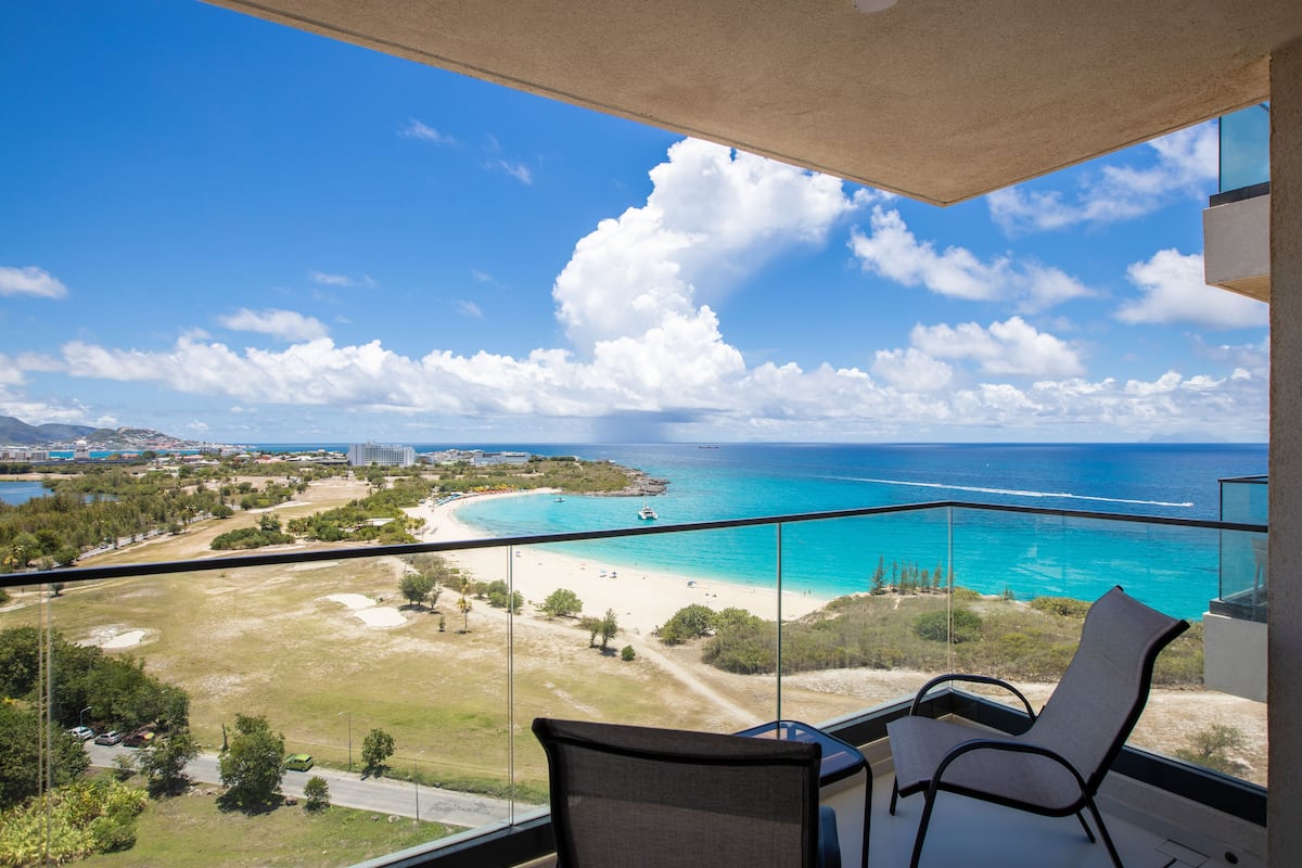 Un balcon avec vue sur une plage et l’océan.