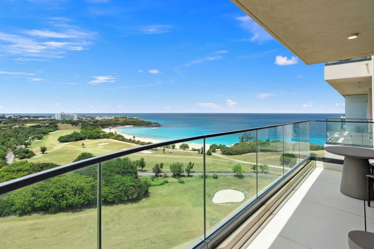 Un balcon offrant une vue dégagée sur un terrain de golf et l’océan.