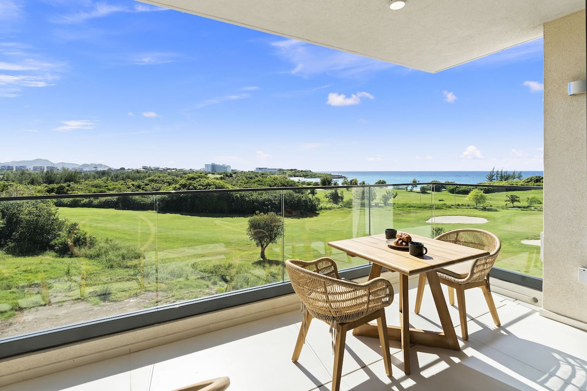 Un balcon offrant une vue dégagée sur un terrain de golf et l’océan.
