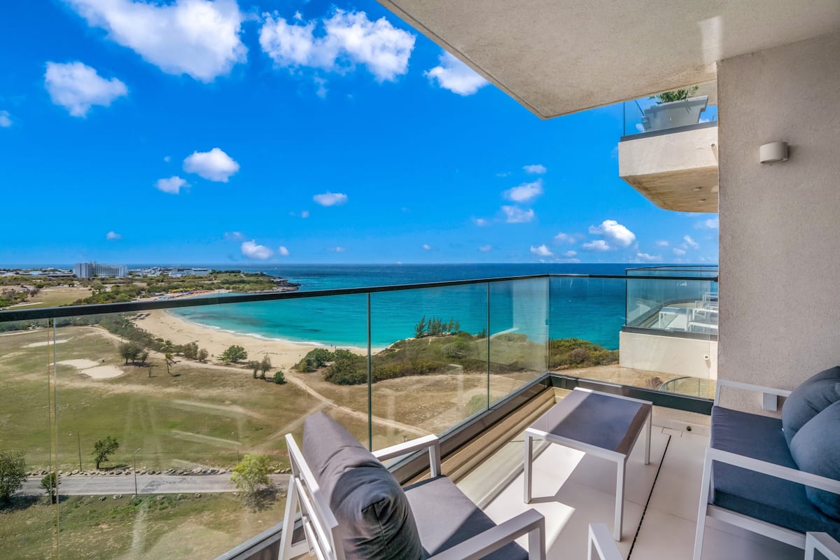 Un balcon offrant une vue dégagée sur une plage et l’océan.