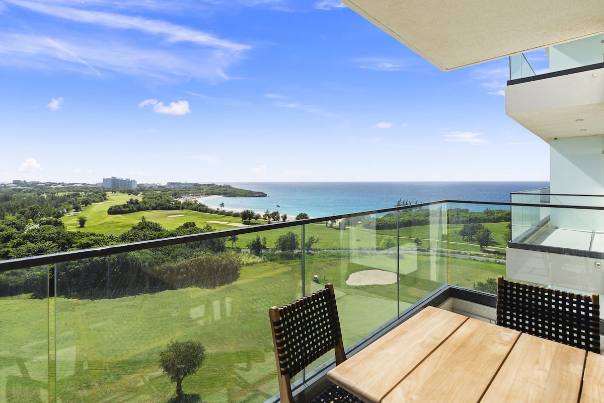 Un balcon offrant une vue dégagée sur un terrain de golf et l’océan.