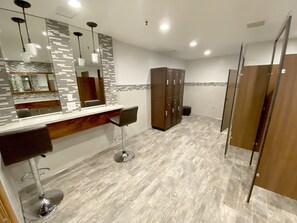 A modern bathroom with a mirror, vanity, and a wooden cabinet.