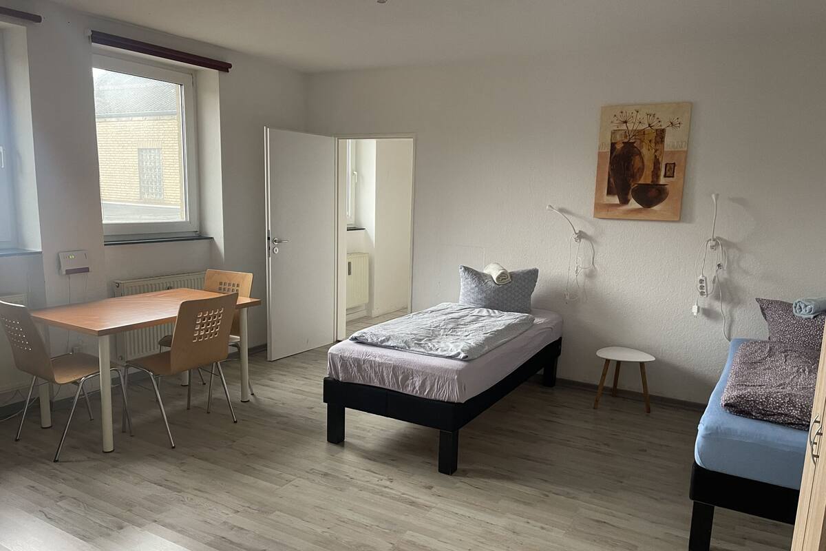 Ein Schlafzimmer mit einem Bett, einem Schreibtisch und einem Stuhl.