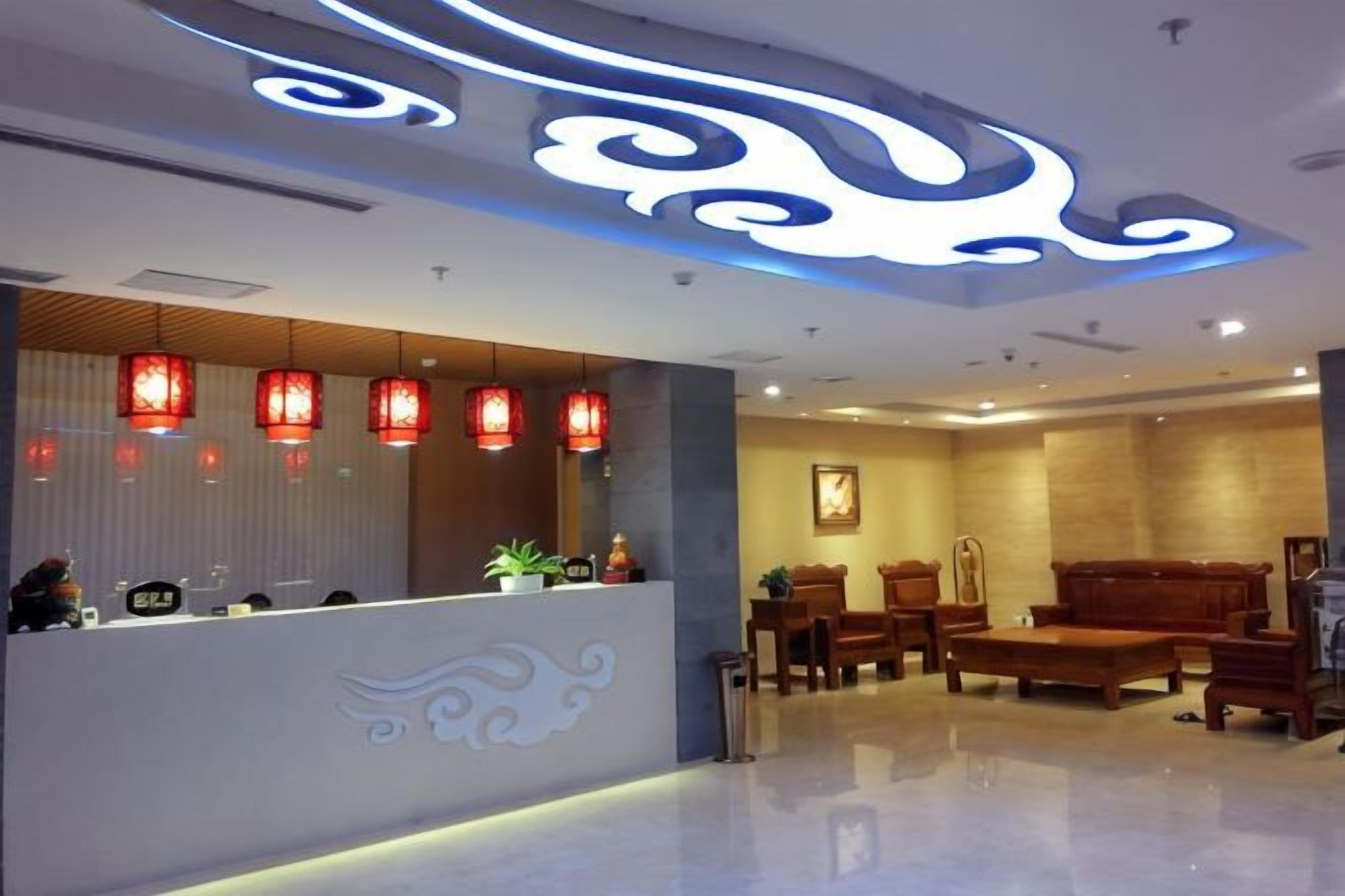 A reception area with a counter, red lanterns, and a seating area with wooden furniture.