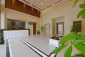 A hotel lobby with a reception desk, a television screen, and a reception area. - Longting Holiday Hostel (Fengkai)