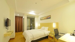A hotel room with a bed, a desk, a chair, a television, and a painting on the wall. - Longting Holiday Hostel (Fengkai)