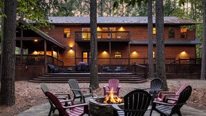 A log cabin with a fire pit and outdoor seating area.