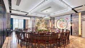 A modern dining area with a round table, chairs, and a decorative centerpiece. - Waterfront Garden Hotel (Huzhou)