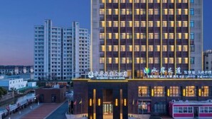 Un hôtel doté d’une façade moderne, de plusieurs étages et d’une entrée bien éclairée.