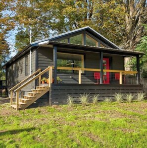 A modern cabin with a wooden staircase leading to a porch, surrounded by greenery. - Chez Cochecton - modern cabin in the Catskills (Cochecton)