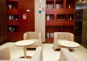 Eine Bibliothek mit Bücherregalen, zwei Sesseln und einem Tisch.