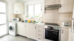 Eine moderne Küche mit Waschmaschine, Mikrowelle, Spüle und Backofen.