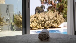 Eine zusammengerollte Handtuch auf einer strukturierten Oberfläche, ein Pool und ein Stativ im Hintergrund.
