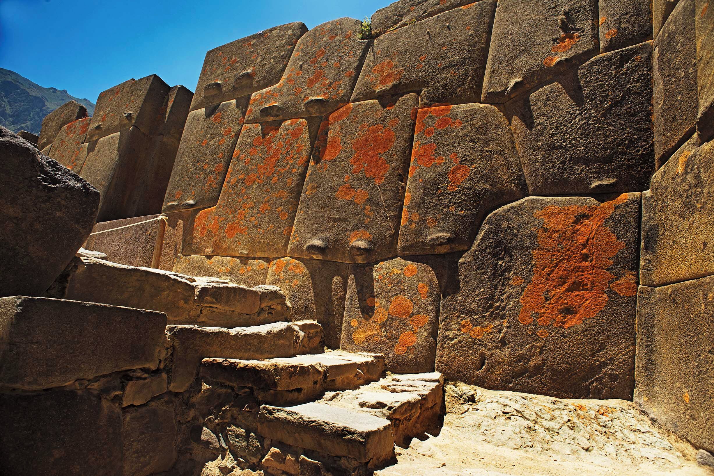 Un muro de piedra con escalones que suben a un nivel superior.