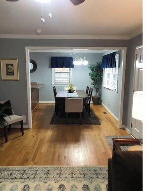 Un espace repas comprenant une table et des chaises, un tapis et un ventilateur de plafond.