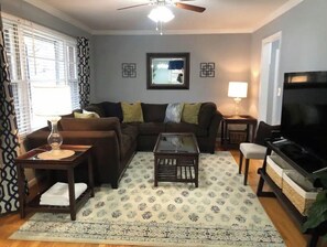A living room with a sofa, coffee table, TV, and decorative items.