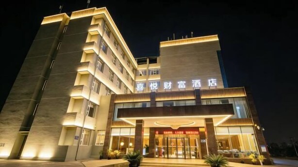 A hotel with a modern design, featuring a prominent entrance and illuminated signage.