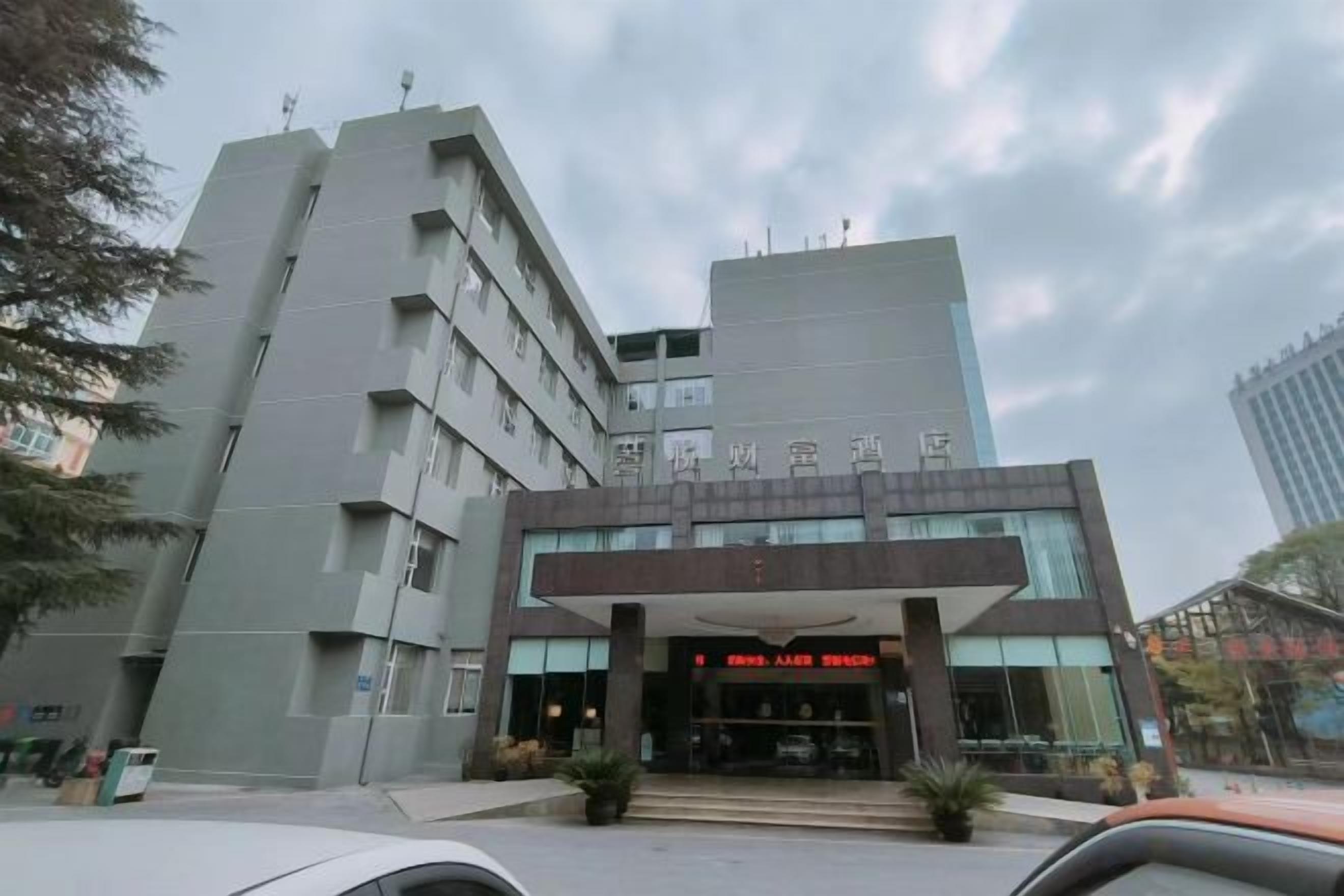 Un edificio de varios pisos con una entrada moderna, ventanas amplias y un letrero que indica un uso comercial.