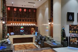 A lobby with a reception desk, seating area, and decorative elements like lanterns and wall art. - Yashe Tianxiang Boutique Hotel (Jiaohe)