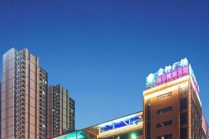 A multi-story building with a prominent sign on the top. - Haibai Taoyuan Hotel (Ningbo)