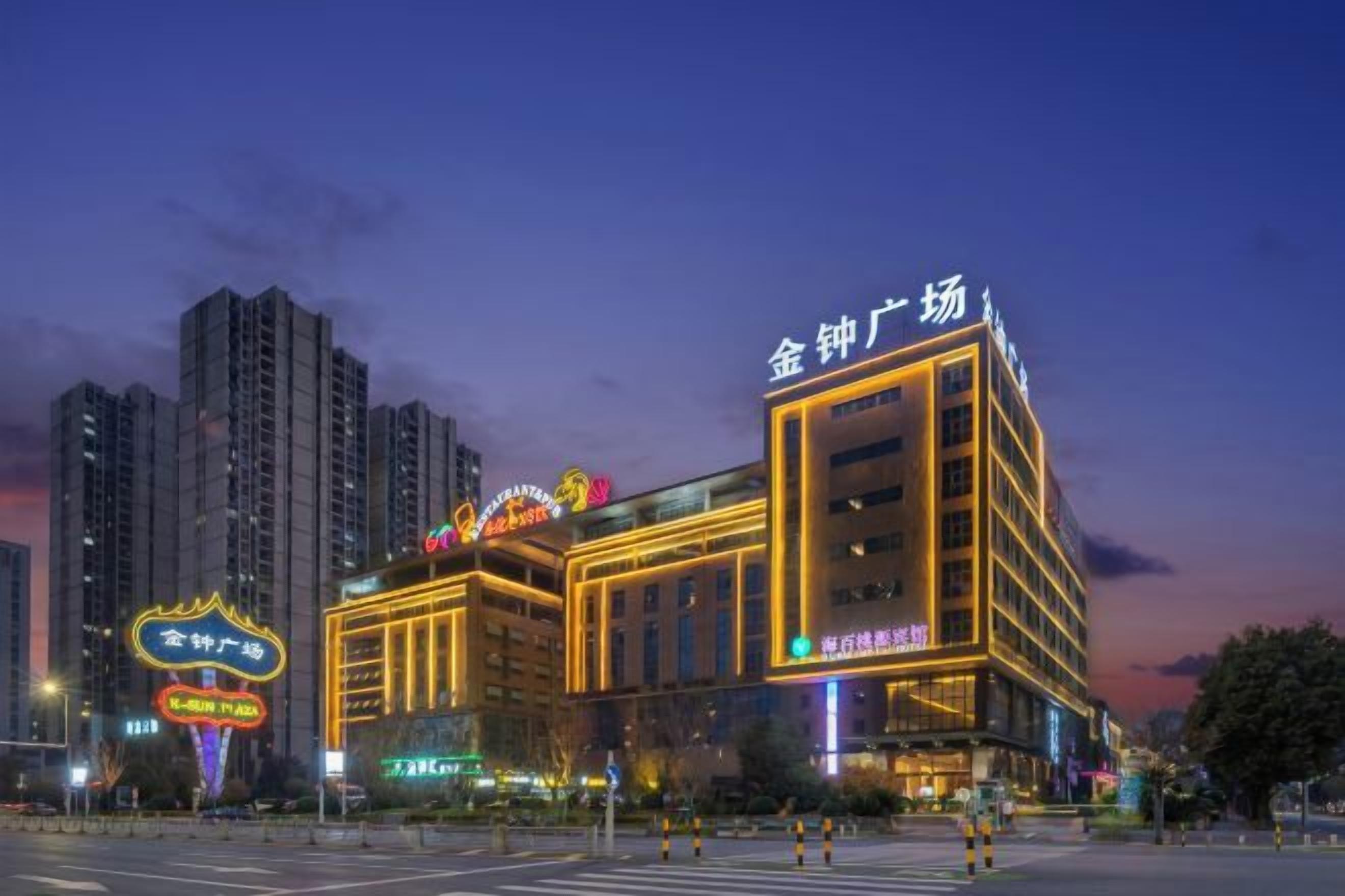 A multi-story hotel with illuminated signage, a prominent entrance, and a crosswalk in front.