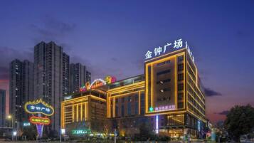 A multi-story hotel with illuminated signage, a prominent entrance, and a crosswalk in front.