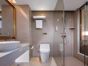 A modern bathroom with a large sink, toilet, and glass-enclosed shower. - Vienna 3 Best Hotel (Guilin)