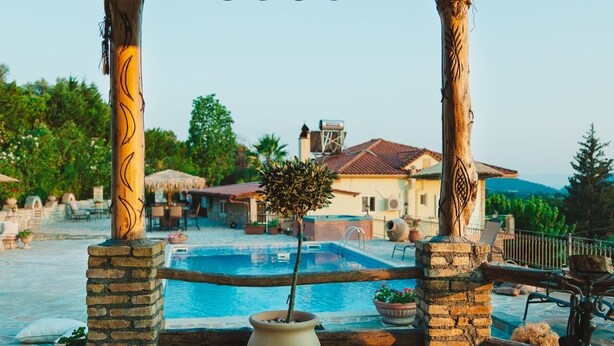 A pool area with a pergola, stone pillars, and a potted plant. - Traditional apartement with pool for relaxation moments (Trikorfo xalkeias)