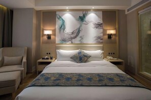A hotel room with a large bed, two bedside tables, a chair, and a wall-mounted artwork. - Shengyang Hotel (Yuxi)