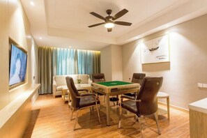 A room with a pool table, chairs, a ceiling fan, a TV, and a sofa. - Shengyang Hotel (Yuxi)