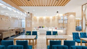 A modern interior with wooden ceiling, tables, blue chairs, a reception desk, and a counter. - Shengyang Hotel (Yuxi)